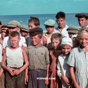 German officer photographing a group of young Ukrainian children standing in front of the Sea of Asov Ukraine 1941