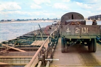 German soldiers in a captured Russian GAZ army truck crossing German river pontoon bridge in Ukraine 1942. Mg34 flak gun