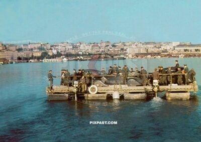 German staff cars and army personnel transported on army ferry across lake in Belgium 1940.
