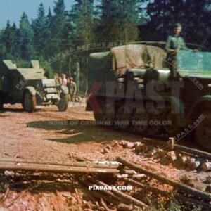 Germany army half track tractor pulling captured Russian armored car IZ ZIS-5 truck out of forest. Russia 1942