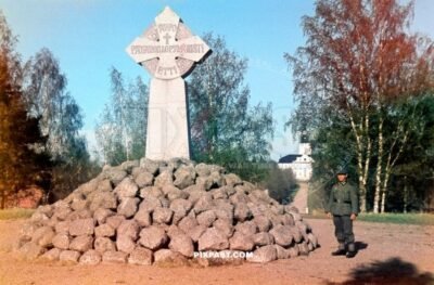 Granite memorial cross erected in 1894 on the site of Korsholm Castle in Old Vaasa Finland 1942. German soldier on the right