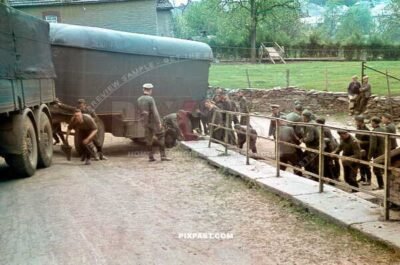 Heavy German Wehrmacht supply truck with trailer in France 1940. Soldiers helping push the trailer around bend.