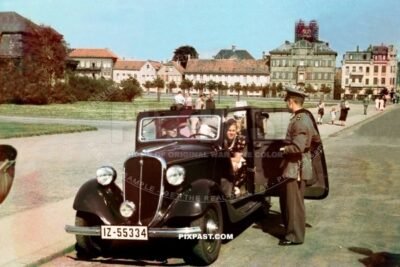 Italian Fiat Balilla 1937 cabrio IZ-55334 parked on street in Western Germany 1937. Soldier in dress uniform.
