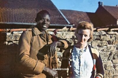 Ivory Coast colonial French infantry soldier captured. German occupation of France 1940. Farmer wife with colorful jumper
