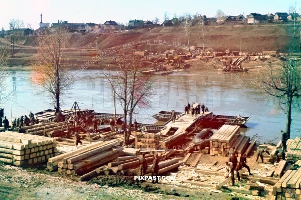 Large German Pioneer unit construction a new timber war bridge using pontoon boats across river Ukraine 1941