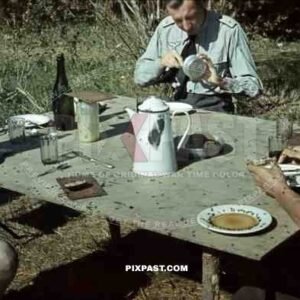 Luftwaffe ground unit officers in summer tunics, Russia summer 1942, eating lunch with bread coffee and flies.
