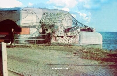 Massive military artillery bunker on the French coast. Colorful camouflage and sand bags and netting. France 1940