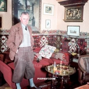 Mein Zimmer bunt 1939. Father of German sailor showing proudly his sitting room. Leather chair, paintings, wall carpet.