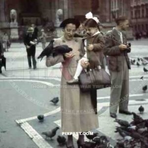 Mother feeding birds with daughter in Odeonsplatz in Munich, Germany 1938, behind Feldherrnhalle,