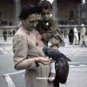 Mother feeding birds with daughter in Odeonsplatz in Munich, Germany 1938, behind Feldherrnhalle,