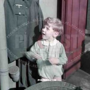 Munich, Germany, 1940. Son of wehrmacht soldier plays with dads army uniform in Munich apartment.