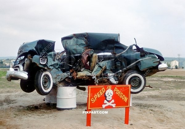 Speed is Poison. Crashed car put on petrol barrels outside of an American US army barracks in Germany 1949