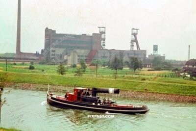 The Old Essen Canal Zeche boat 1938 Essen Germany. Behind coal mine and factory.  Tug boat.