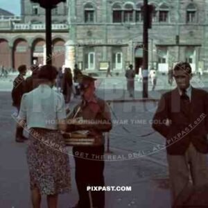 Ticket seller outside front of Munich Main Train Station, Germany. 1940. Tram driving down Arnulfstrasse
