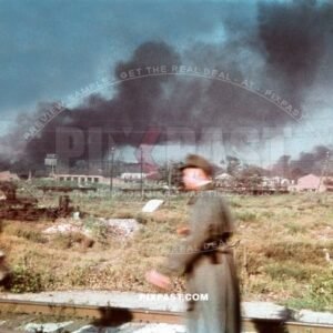 Two German Wehrmacht soldiers walking on a rail track beside a burning factory on the outskirts of Stalingrad Russia 1942