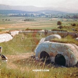 Two German soldiers looking at a French army bunker concrete fort. Part of the Maginot line France 1940