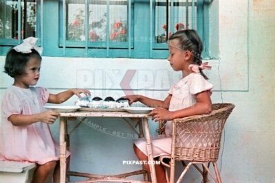 Two little girls eat cream cakes in Budapest Hungary summer 1940