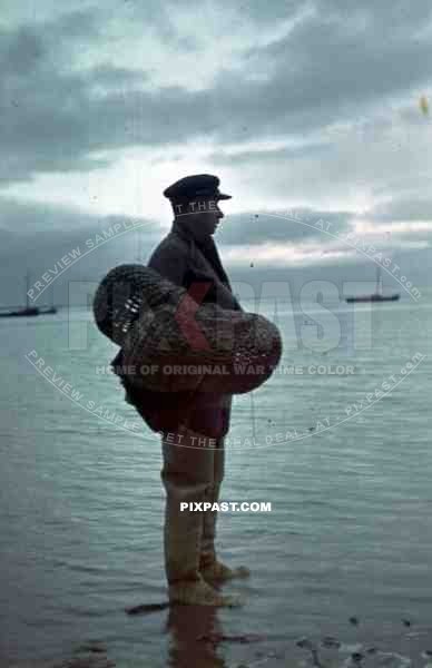 Ukrainian fisher man with nets on the beach of Sudak Bay, Crimea, Ukraine 1942, 22nd Panzer Division.