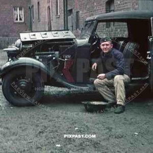Wehrmacht soldier repairing car in Niederaußem, Germany 1940