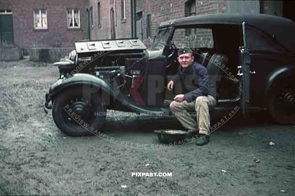 Wehrmacht soldier repairing car in Niederaußem, Germany 1940