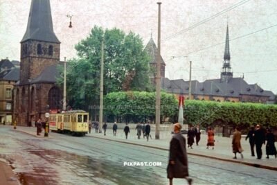 Yellow Number 2 Tram Strassenbahn passing St. Johann Baptist Church in Essen Germany 1941. Bomb monument red fin.
