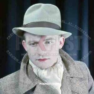 Young Austrian man in American style 20s hat and jacket with red lipstick, theatre show 1937, Later becomes war reporter.