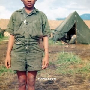 Young New Guinea boy in make shift American tropical army uniform helping US troops in New Guinea 1944