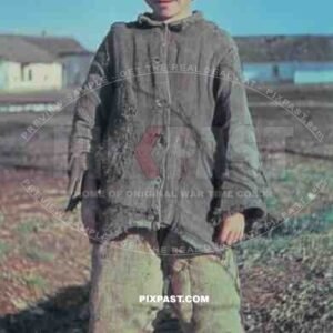 Young Russian farmer boy wearing traditional hat in Village. photographed by German war reporter. Russia 1943.