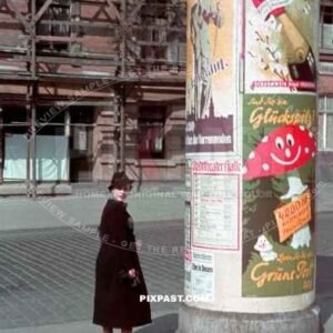 Young women reading posters on a Advertising column. Litfasssaule. for the Halle Saale Theatre ( Saxony-Anhalt ) 1940